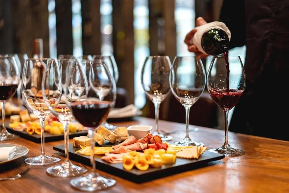 Wine tasting: red wine being poured into a glass beside a charcuterie board (1 of 7)